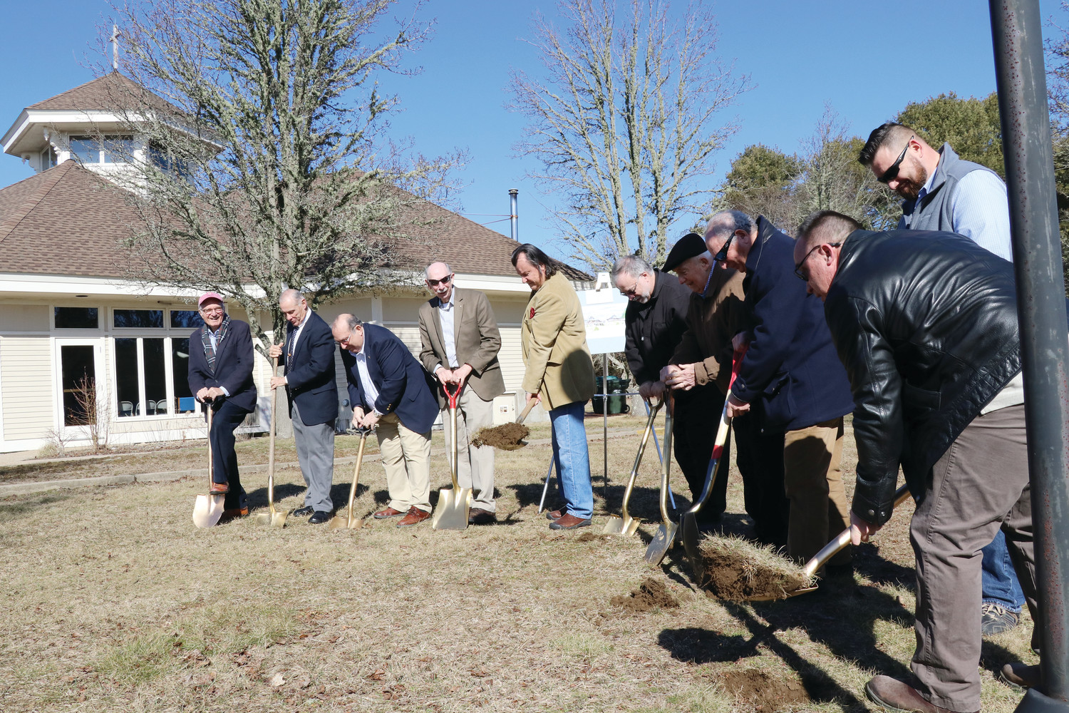 From left, Leo Mainelli, Dave Sloan, Jim White, Doug Noble, Barry Goewey (project architect), Father Paul Desmarais, Ron DuBois, Mike Cocci (builder), Tom Canning and Richard Lambert break ground on the project on Feb. 24, as parishioners look on.